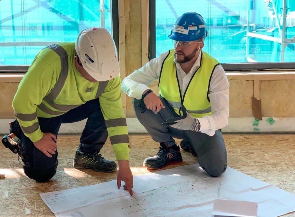 To ansatte i Rom Sprinjler som går over plantegninger